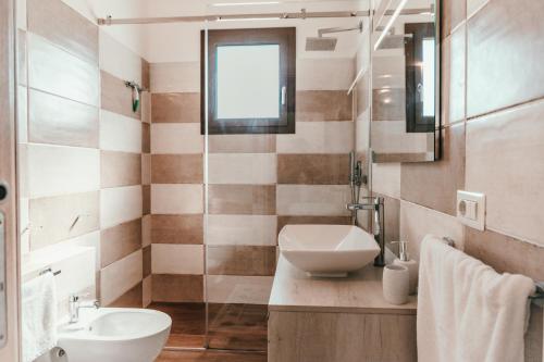 a bathroom with a sink and a toilet at VILLA INDIPENDENTE AL MARE BUDONI in Tanaunella