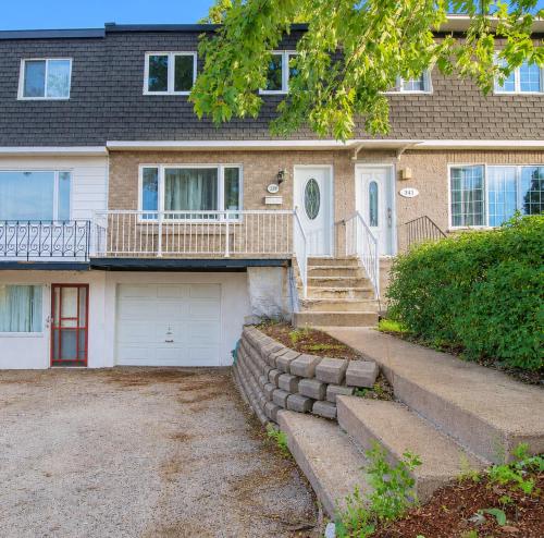 a large house with a porch and a driveway at Refuge urbain du Trait-Carré in Laval