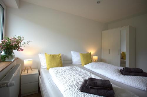 a bedroom with two beds with yellow pillows at Trüffelhof 1 in Bodman-Ludwigshafen