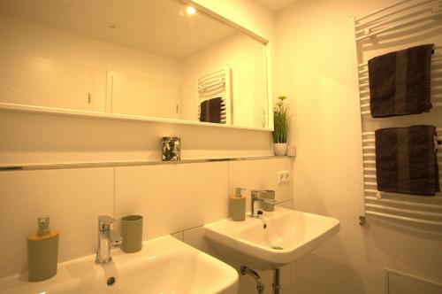 a white bathroom with a sink and a mirror at Trüffelhof 1 in Bodman-Ludwigshafen