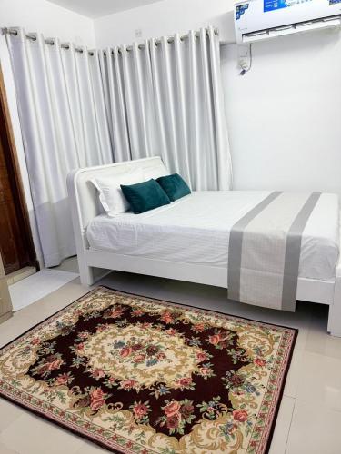 a bedroom with a bed with a rug on the floor at Havene 11 in Dhaka
