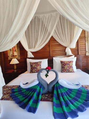 a bedroom with two beds with swans on them at Bukit Luah Sidemen in Sidemen