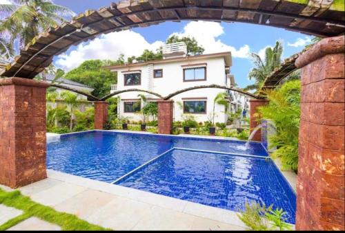 a swimming pool in front of a house at 4BHK Villa in Anjuna with Jacuzzi & Pool in Anjuna