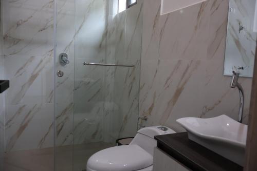 a bathroom with a shower and a toilet and a sink at LAS 7 CASCADAS Campground - Restaurant - Lodge in Cacaoal