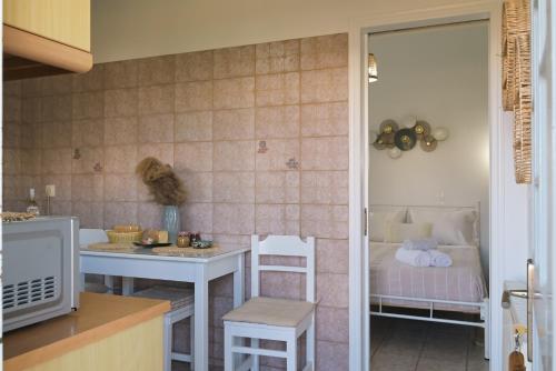 a kitchen with a table and a bed in a room at Studios Margarita in Artemonas