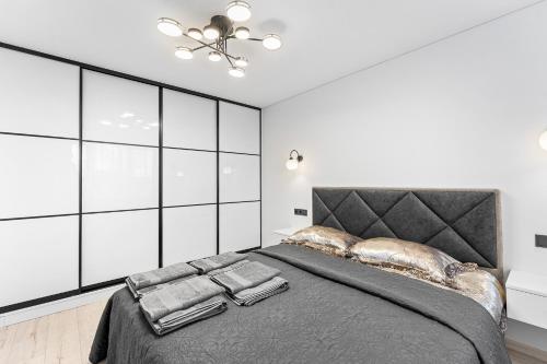 a bedroom with a large bed with pillows on it at Korsako apartamentai in Šiauliai