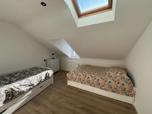 a attic bedroom with a bed and a window at vannes évasion in Vannes