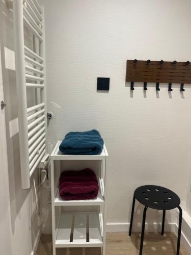 a room with a stool and a shelf with towels at vannes évasion in Vannes