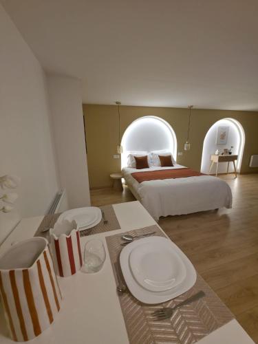 a room with two beds and a table with plates on it at Les arches in Riom