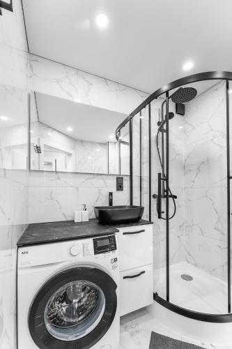 a bathroom with a washing machine and a shower at Korsako apartamentai in Šiauliai