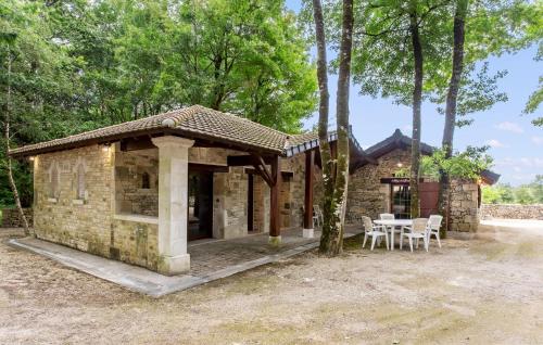 a small stone house with a table and chairs at Amazing Home In Lonnes With Heated Swimming Pool in Lonnes