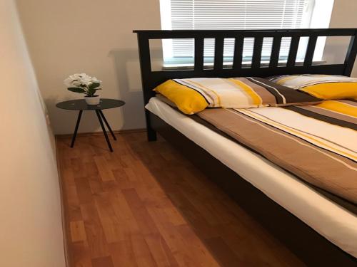 ein Schlafzimmer mit einem Bett und einem Tisch mit einer Blumenvase in der Unterkunft Apartment Am Ring in Bochum