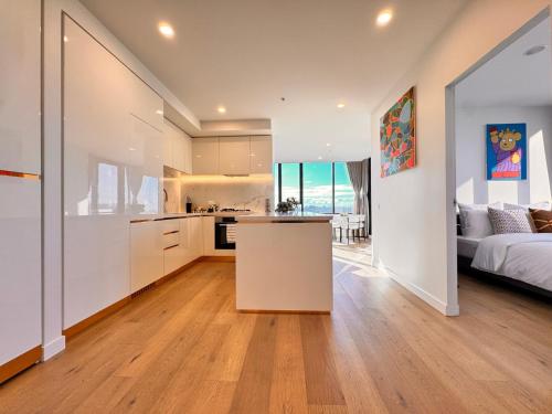 a kitchen and a living room with a bed and a kitchen and a kitchen island at Skyline Views Premium 2B2B Free Parking Box Hill in Box Hill