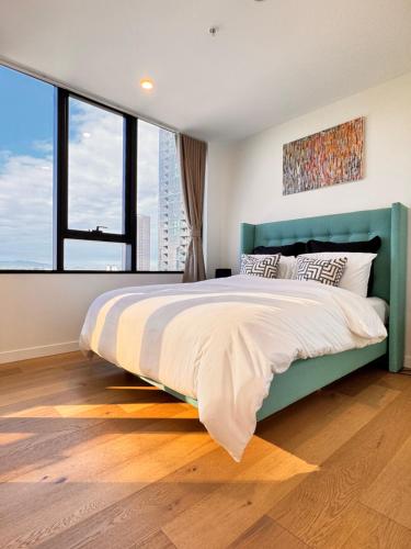 a bedroom with a large bed with a large window at Skyline Views Premium 2B2B Free Parking Box Hill in Box Hill