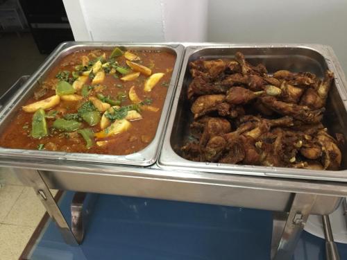 two trays of food with meat and sauce on a table at Oriental Nights Rest House in Al Wāşil