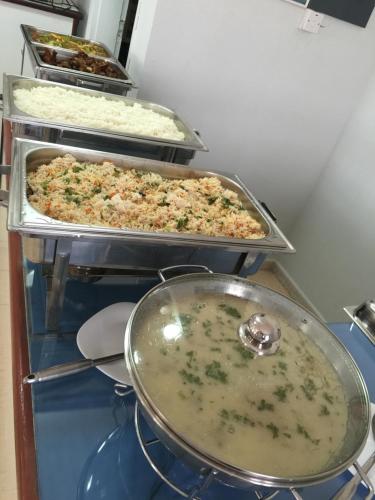 two trays of pizzas sitting on top of a table at Oriental Nights Rest House in Al Wāşil