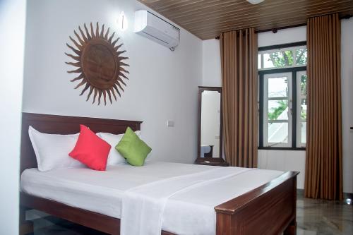 a bedroom with a large bed with colorful pillows at Breeze 12 Villa in Negombo