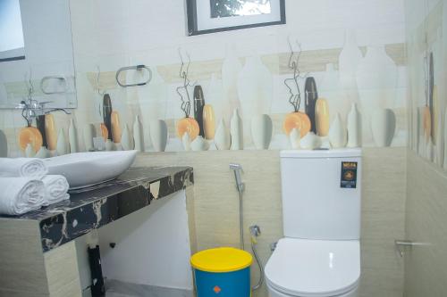 a bathroom with a counter with a toilet and vases on the wall at Breeze 12 Villa in Negombo