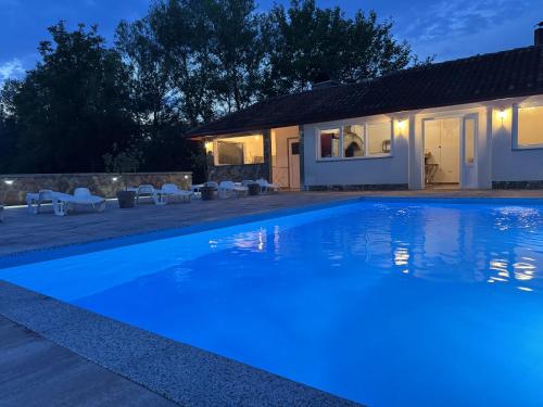 a swimming pool in front of a house at night at Althea Home & Wellness in Bihać