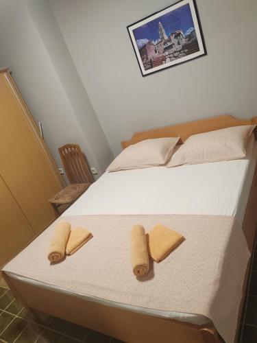 a bedroom with a bed with two slippers on it at Apartmani Ferri 1 in Vrbanj