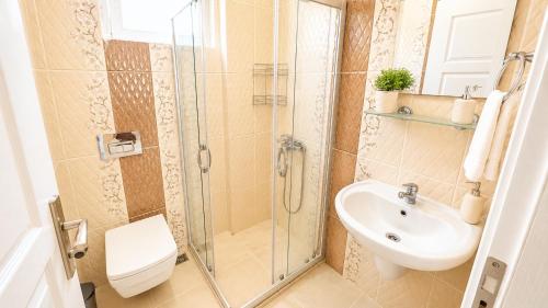 a bathroom with a shower and a sink and a toilet at Fethiye Merkezde Lüx Daire in Fethiye