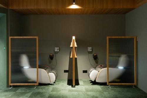 a bathroom with two mirrors and a bath tub at Oani in Taipei