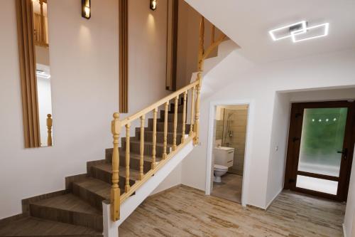 a staircase in a home with white walls and wood floors at Vila MIHAI in Văliug