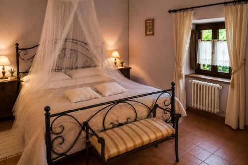 a bedroom with a large bed with a canopy at Il Borghetto di Pedana- in Città di Castello