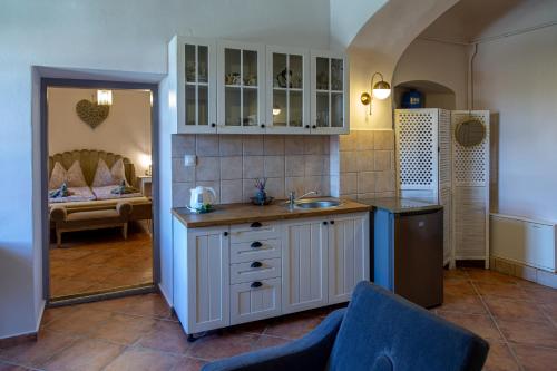 a kitchen with a sink and a room with a bed at Köveskál Vendégház in Köveskál