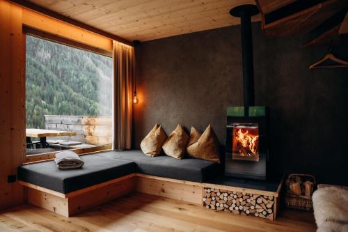a room with a bed with a fireplace and a window at Chalet Tschogerhof Tiers am Rosengarten Dolomiten in Tires