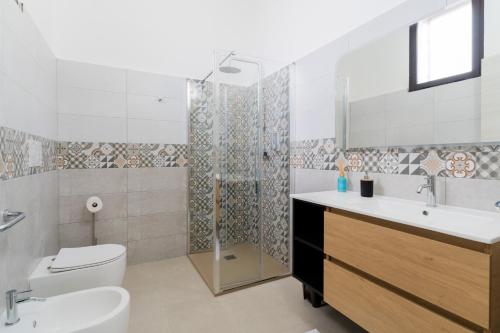 a bathroom with a toilet and a sink and a shower at Al Calico in Galatone