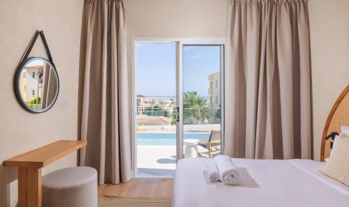 a hotel room with a bed and a view of a pool at WellClub Resort - Suites & Wellness in Paphos