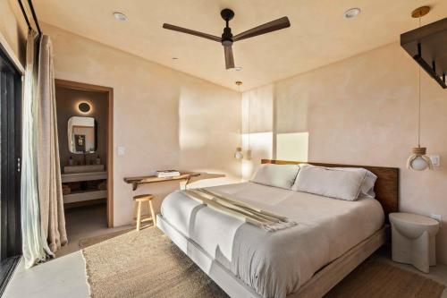 a bedroom with a bed with a ceiling fan at Sand Tulum Retreat w Pool Spa in Yucca Valley