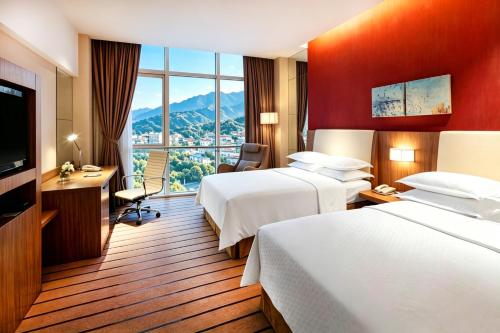 a hotel room with two beds and a large window at 泰安宝龙艺珺酒店 in Tai'an