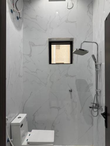 a white bathroom with a toilet and a window at شقق ميلا الباحة الفاخرة in Al Baha
