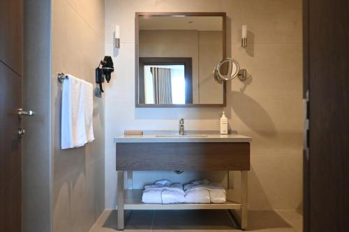 a bathroom with a sink and a mirror and towels at Ramada by Wyndham Duzce in Duzce