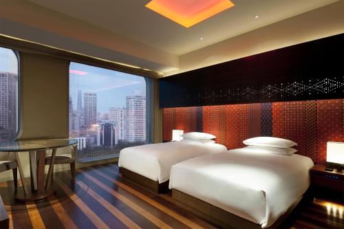 two beds in a room with a view of a city at Andaz Xintiandi, Shanghai, By Hyatt in Shanghai