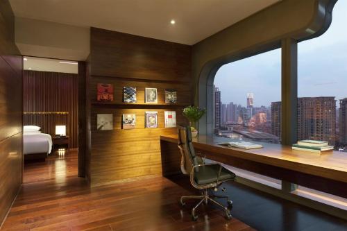 a bedroom with a desk and a bed and a window at Andaz Xintiandi, Shanghai, By Hyatt in Shanghai