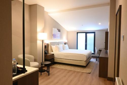 a hotel room with a bed and a chair at Ramada by Wyndham Duzce in Duzce