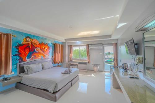 a bedroom with a large bed with a painting on the wall at BCP Hotel in Ban Chang