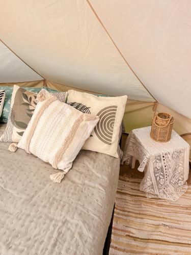a bed in a tent with pillows and a table at Lahemaa Nature Glamping - Eha in Vihasoo
