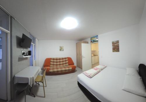 a small room with a bed and a couch at Garsonjera - centar Igalo in Igalo
