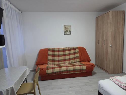 a living room with a couch with a plaid blanket at Garsonjera - centar Igalo in Igalo