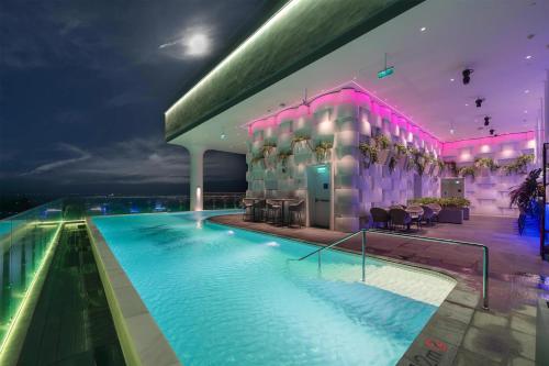 a hotel swimming pool at night with pink lighting at Wink Tuy Hoa Beach, Unscripted by Hyatt - 24 Hours stay in Tuy Hoa