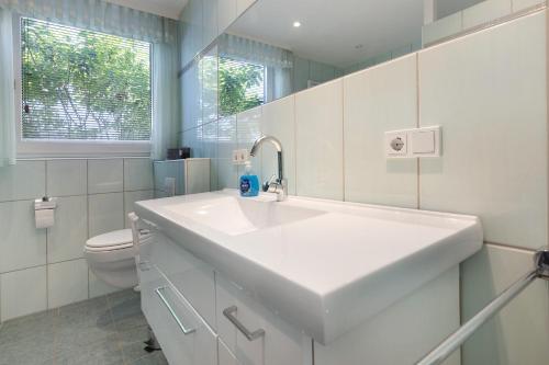 a white bathroom with a sink and a toilet at Ferienhaus Leni in Edertal