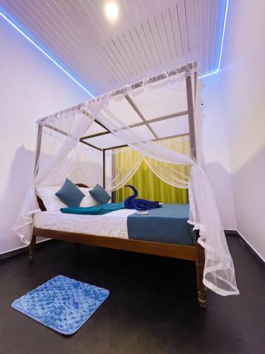 a bed with a canopy in a room with a rug at Bule Bells Villa in Matara