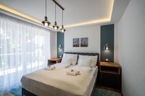 a bedroom with a large bed with two stuffed animals on it at Sunshine Homes Zamárdi in Zamárdi