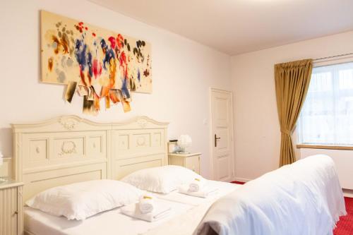 a bedroom with two beds and a painting on the wall at Penzion Hněvotín 88 in Hněvotín