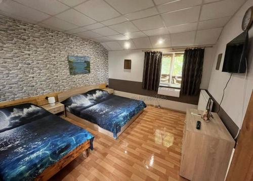 a bedroom with two beds and a brick wall at Rapan Guesthouse in Bŭlgarevo