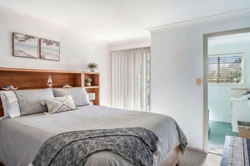 a bedroom with a large bed with a wooden headboard at 5-41 Park Street in Evans Head
